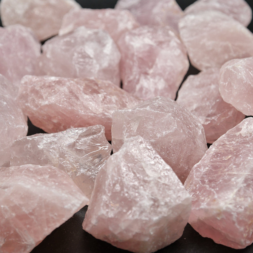Close-up of pink ROSE QUARTZ crystal rocks on a dark background