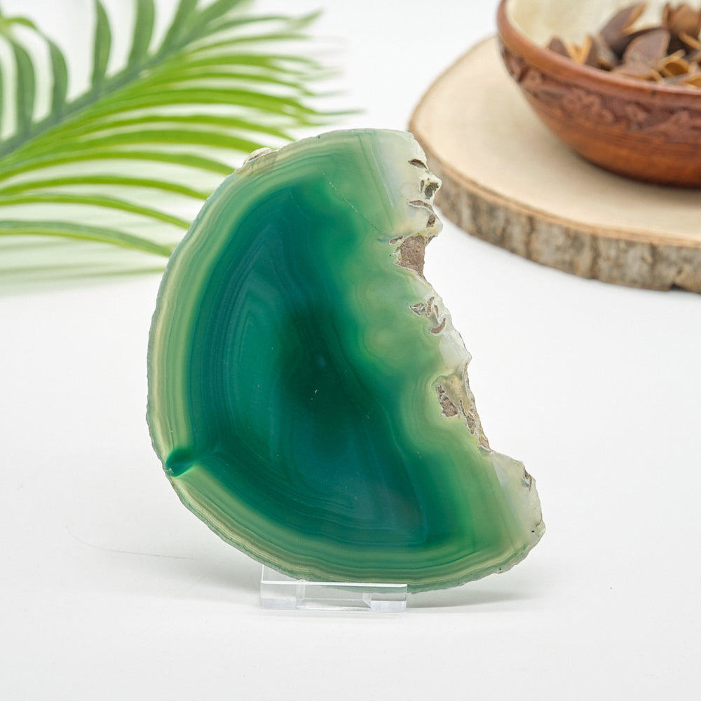 Green agate stone on a clear stand with a natural background