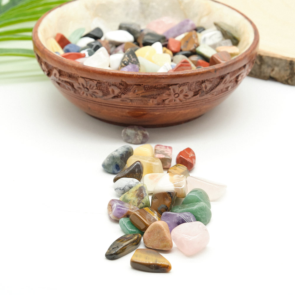 Decorative bowl with multicolored stones on a white surface