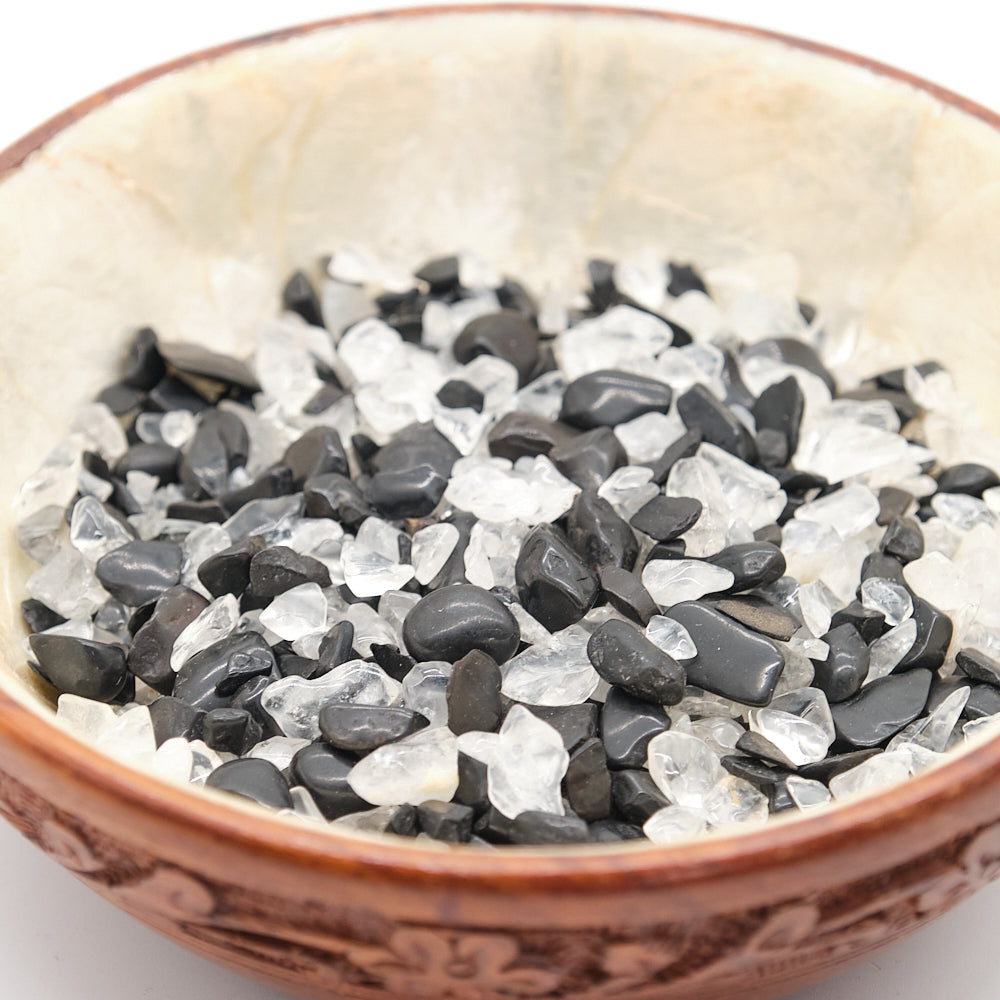 Small bowl filled with black and white crystals on a light background
