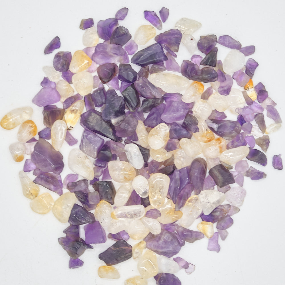 Assorted small amethyst and citrine stones on a white background