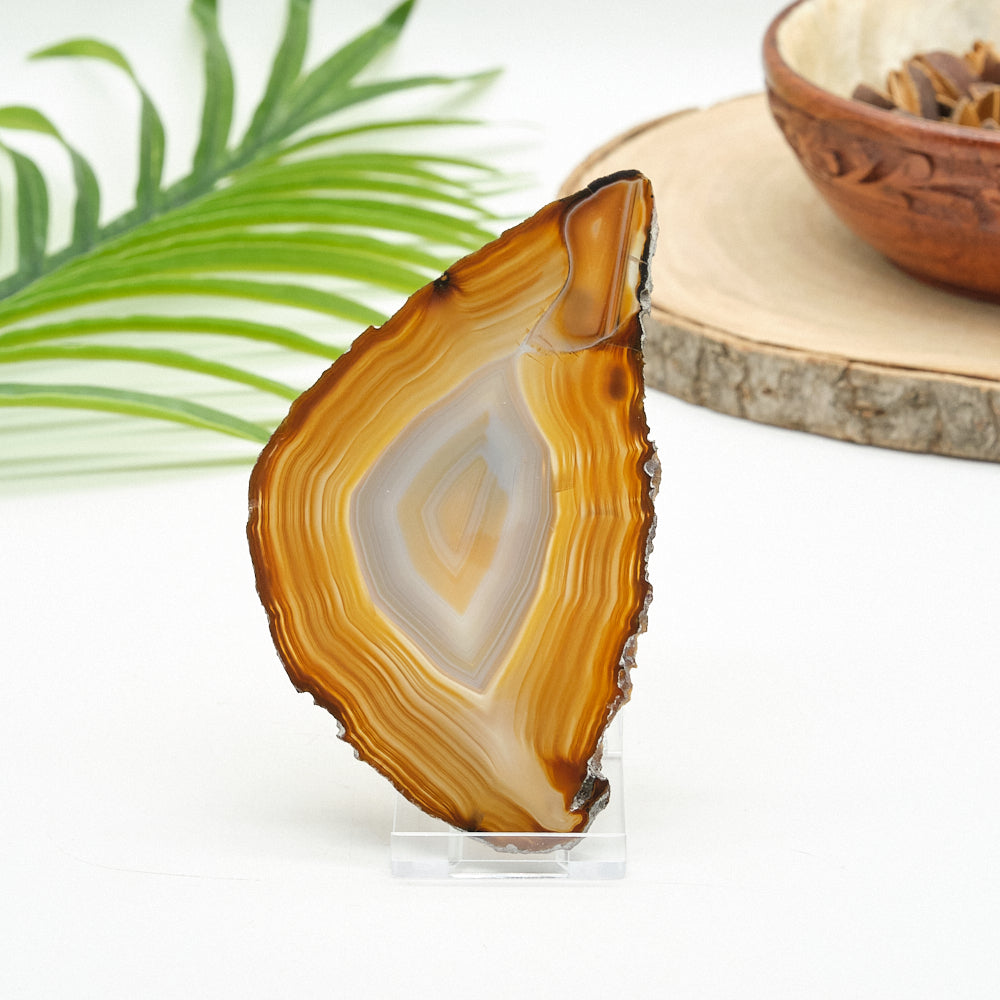 Sliced agate stone on a stand with a wooden coaster and bowl in the background