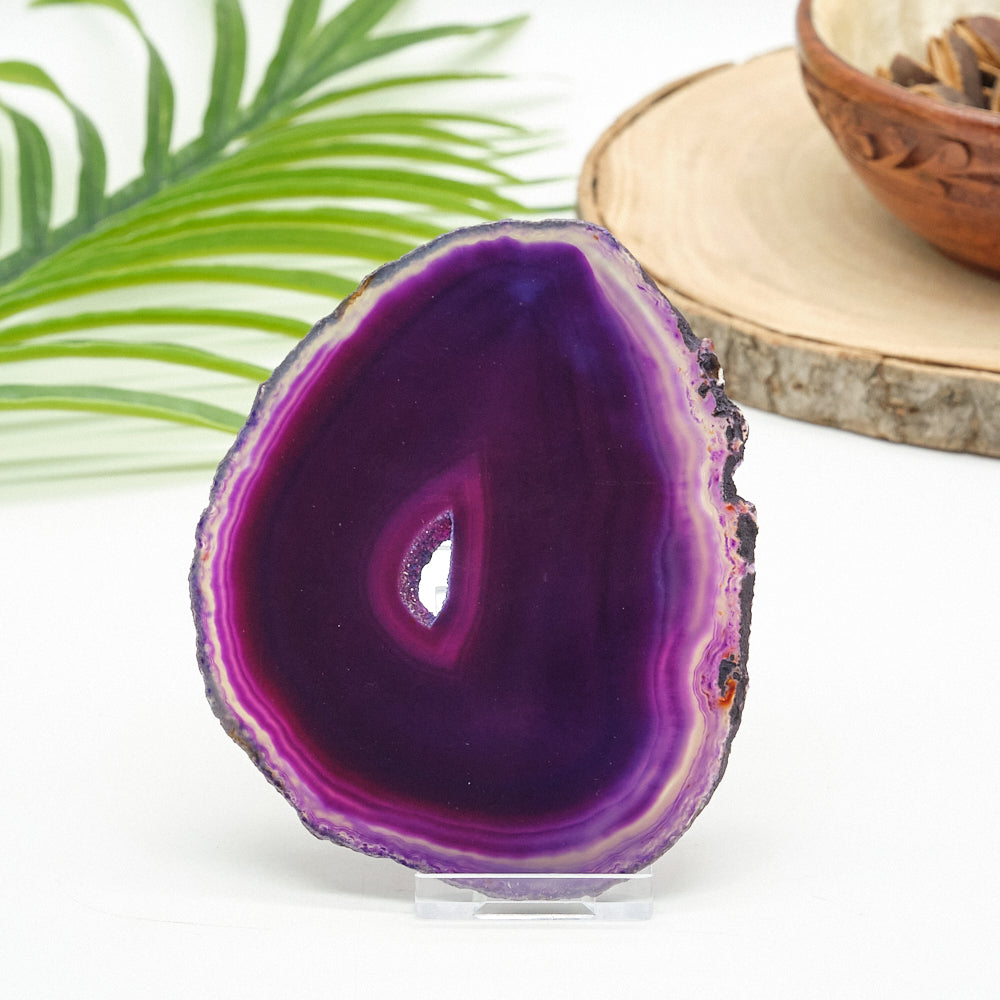 Purple agate slice on a white surface with a natural background