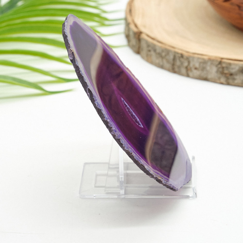 Purple agate stone on a clear stand with a natural background