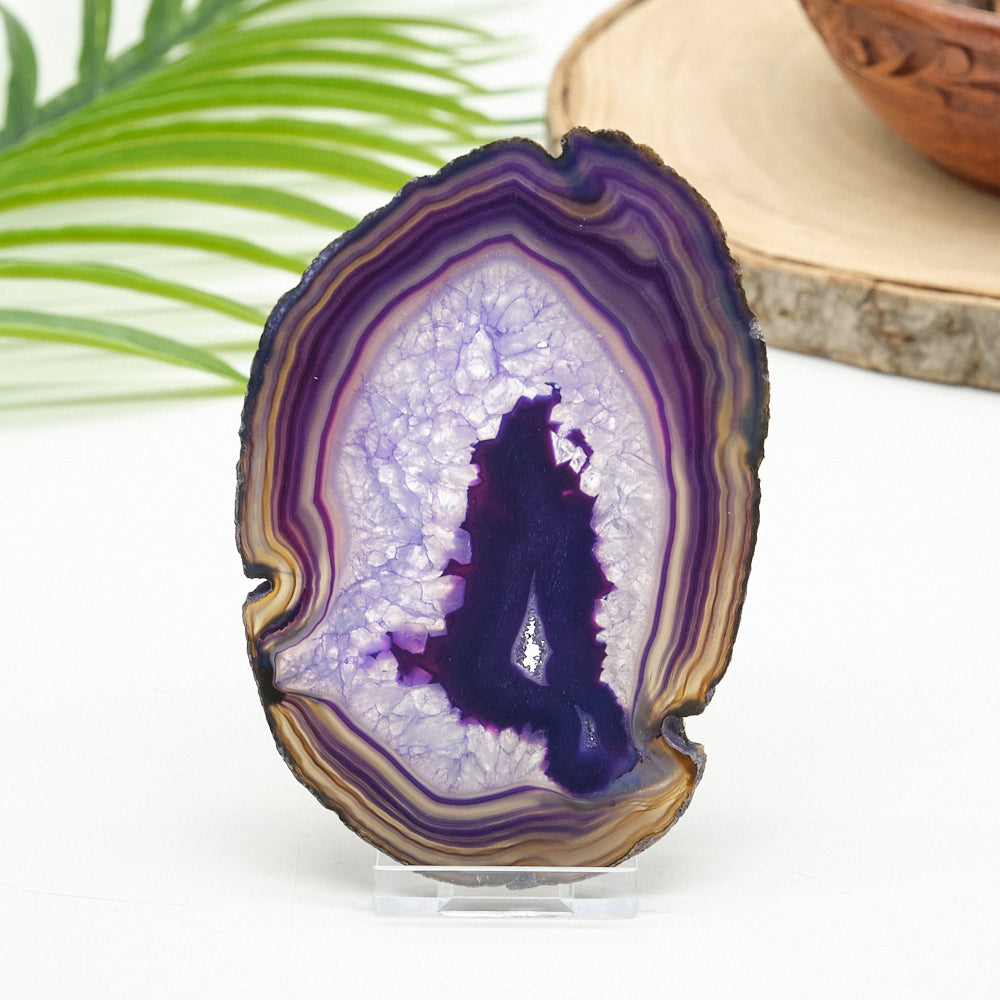 purple agate slice on a clear stand against a white background