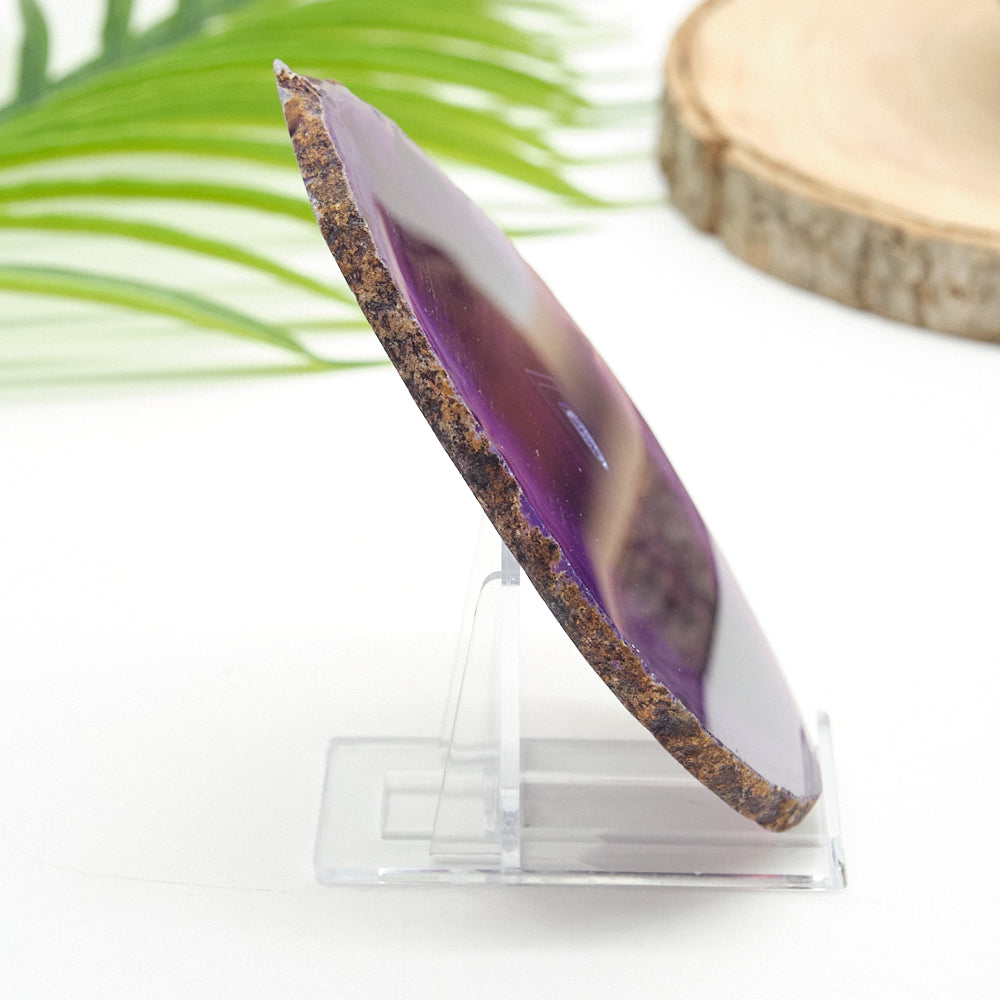 Purple agate stone on a clear stand with a natural background