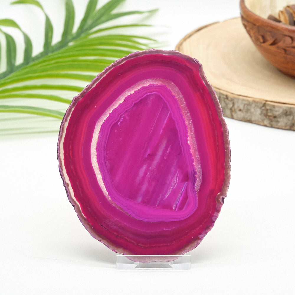 Pink agate stone on a stand with a blurred natural background