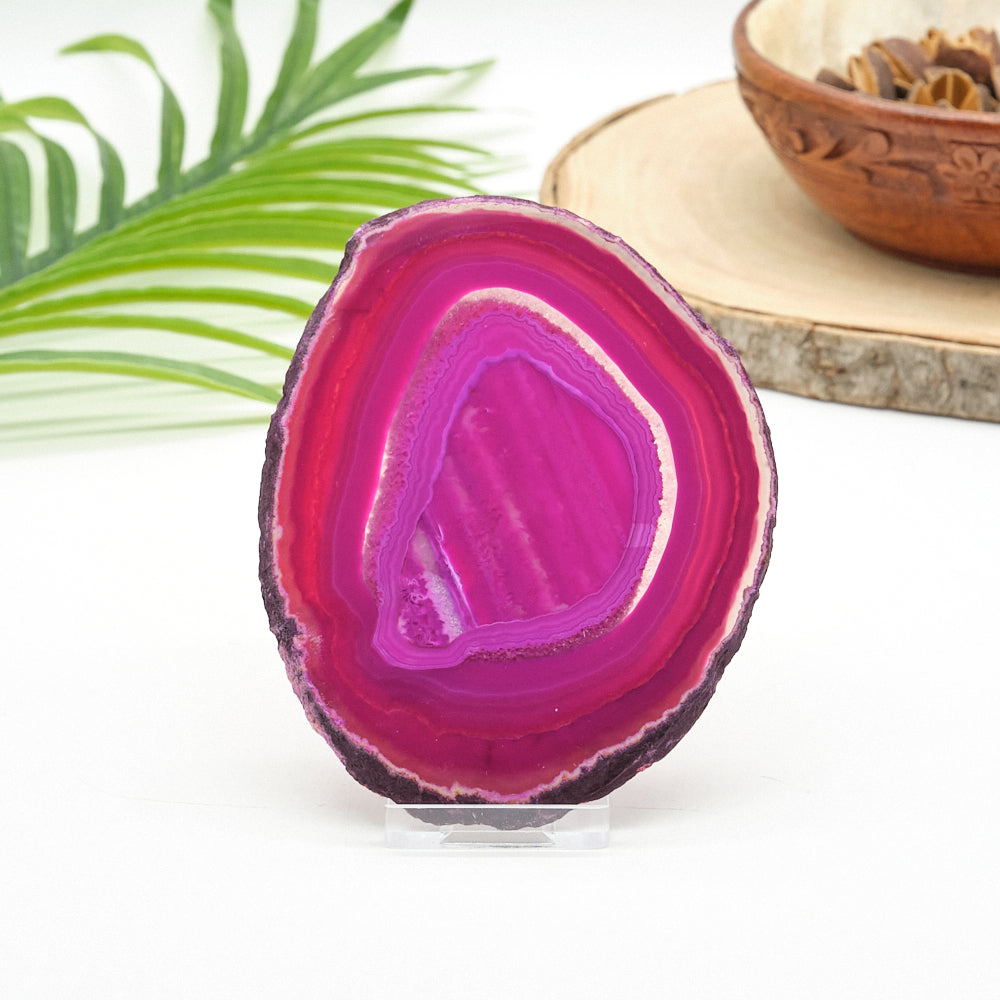 Polished agate stone with vibrant pink interior on a white background