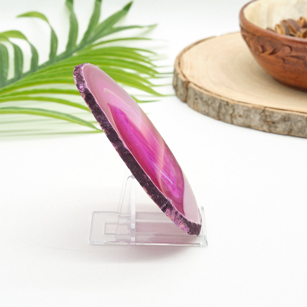Pink and purple agate stone on a clear stand with a natural background