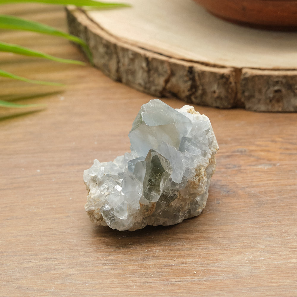 blue celstite Crystal rock on a wooden surface with a natural background