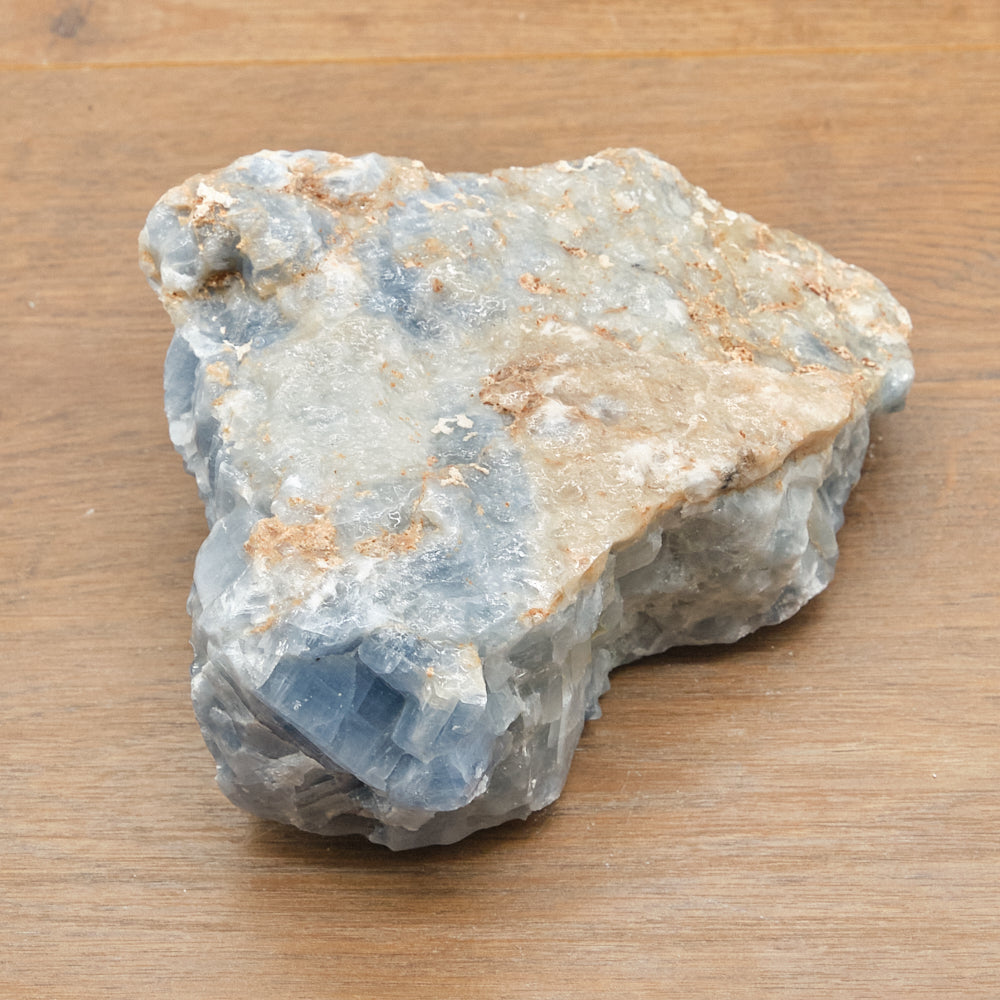 Raw calcite crystal rock on a wooden surface