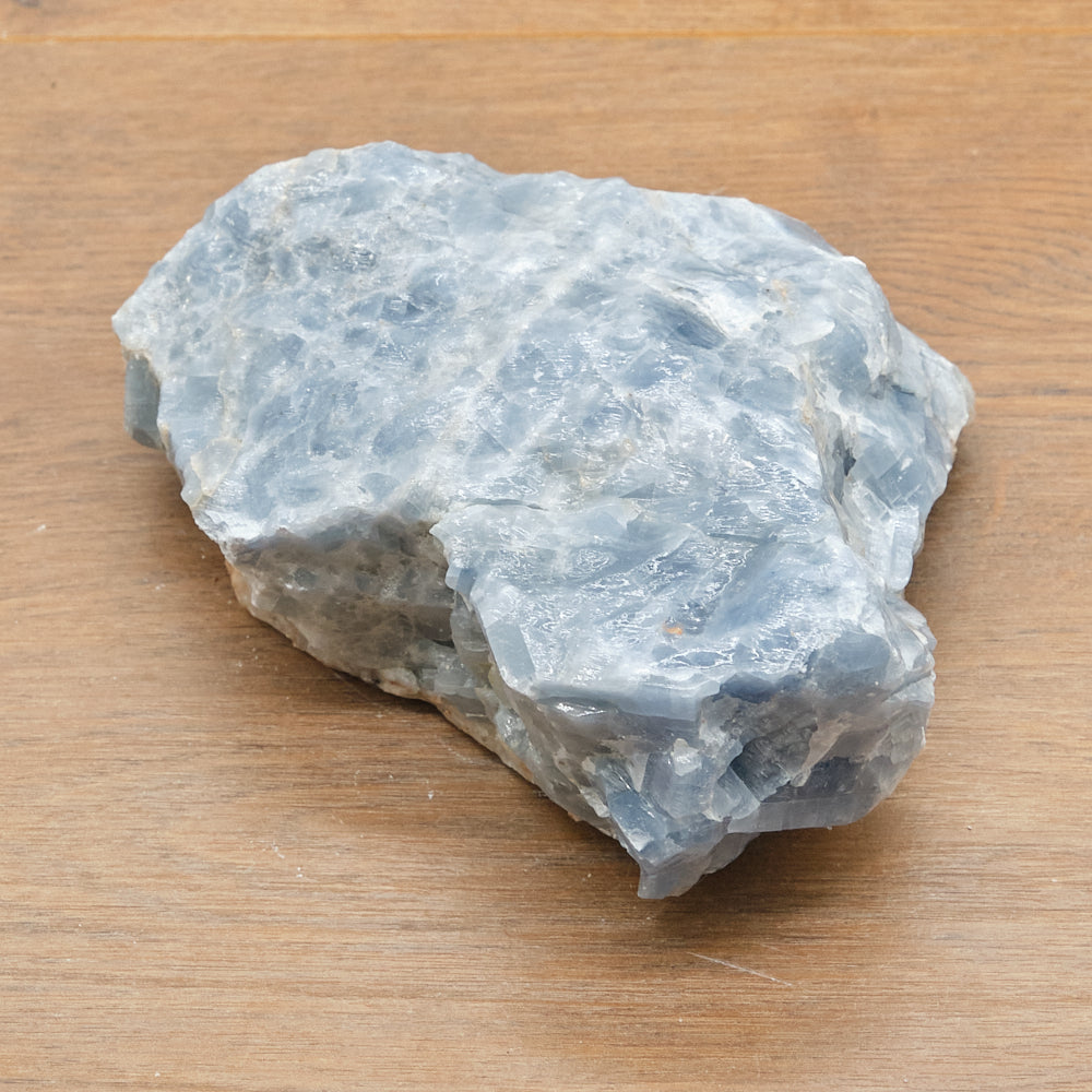 Raw blue calcite stone on a wooden surface