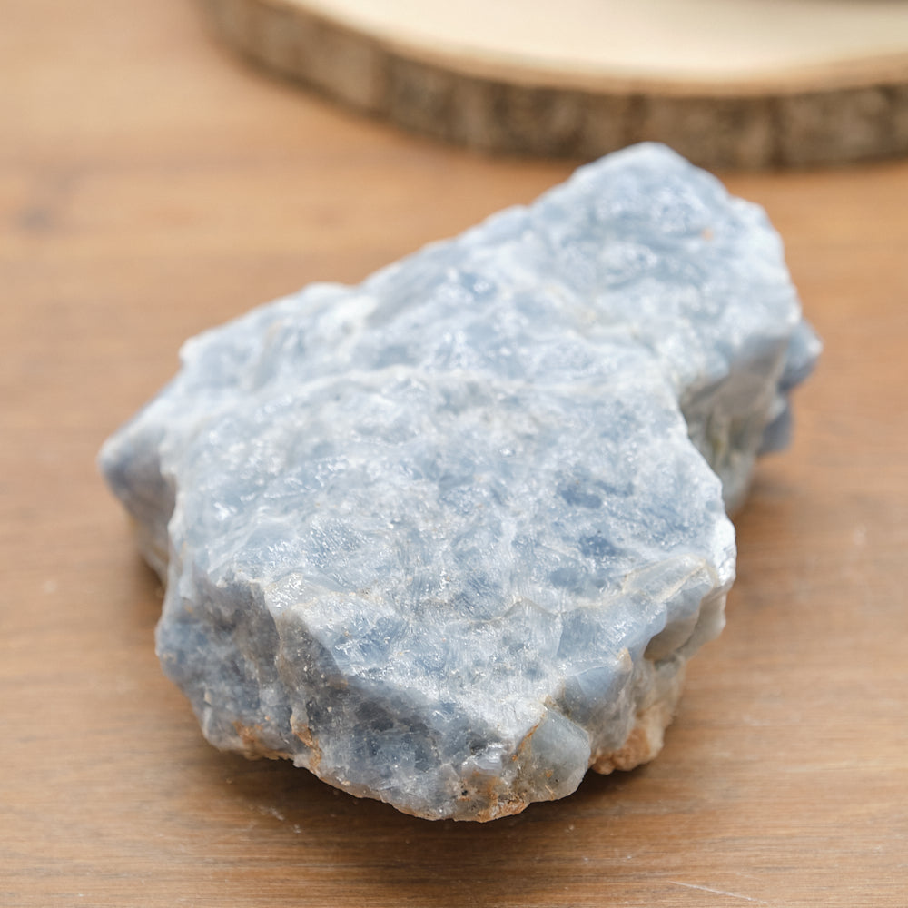 Raw blue calcite stone on a wooden surface