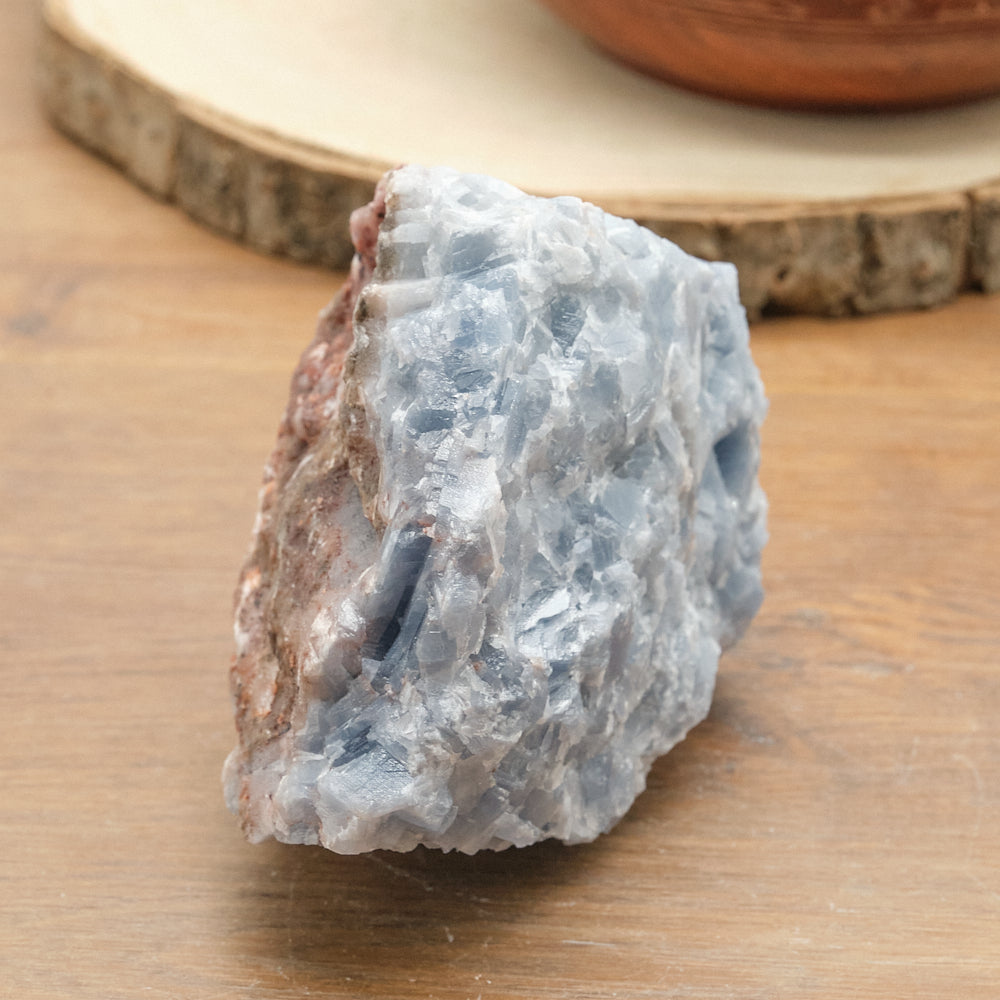 Raw calcite crystal rock on a wooden surface