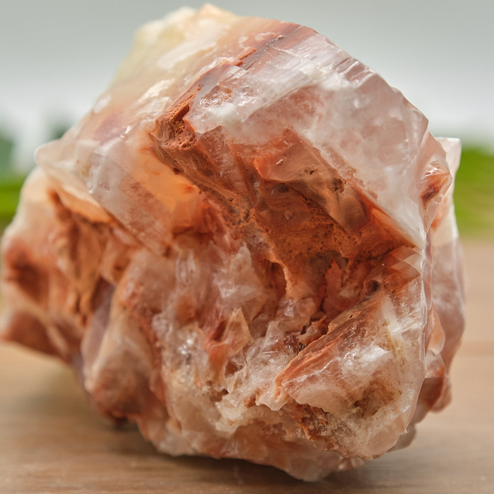 Close-up of a calcite crystal rock on a wooden surface with a blurred background
