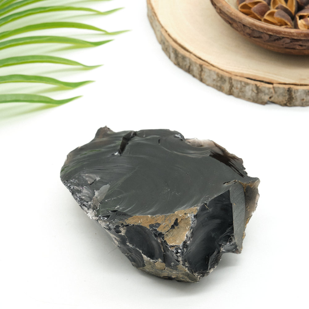 Raw obsidian stone with natural texture on a white background