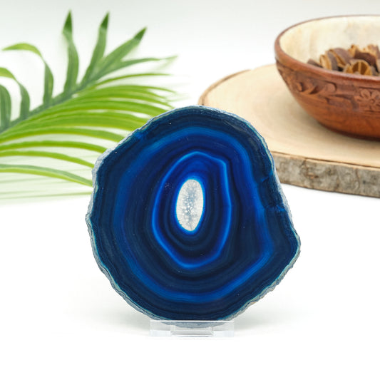 Blue agate slice with a plant and wooden bowl in the background