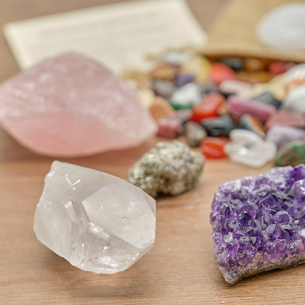 Close-up of various crystals on a wooden surface with a blurred background.