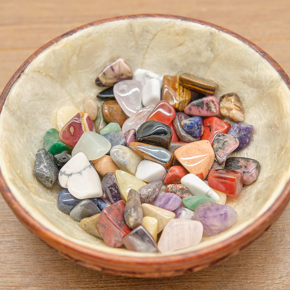 bowl filled with multicolored stones on a wooden surface