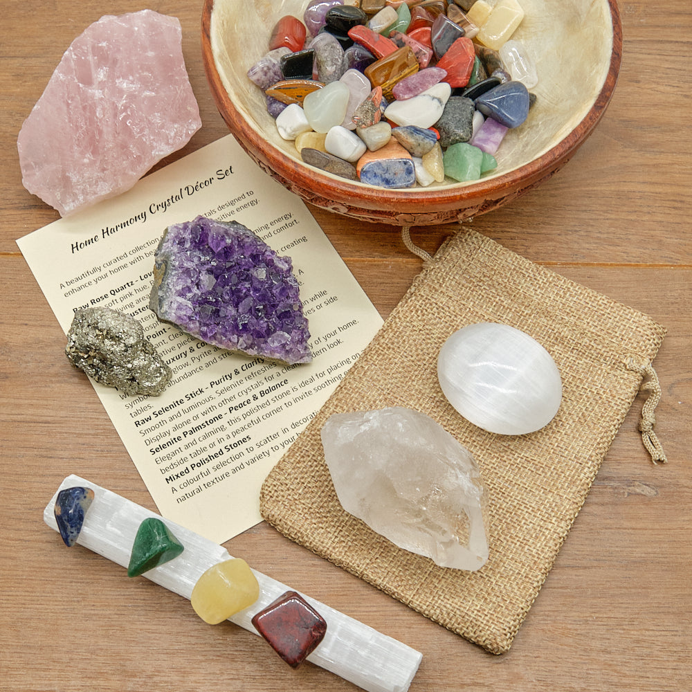 Collection of crystals and crystal tools on a wooden surface with a bowl of stones.