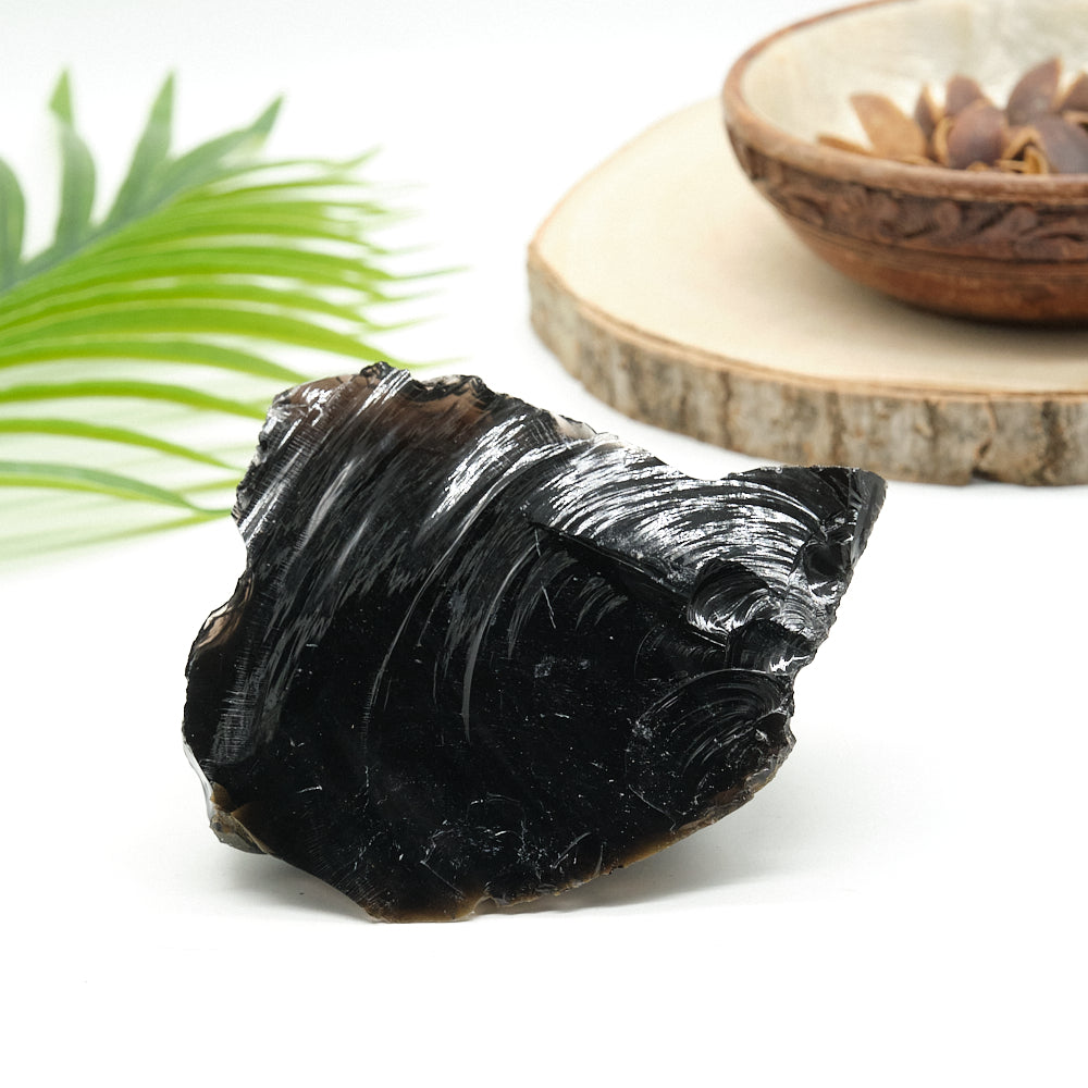large rough black obsidian rock on white surface