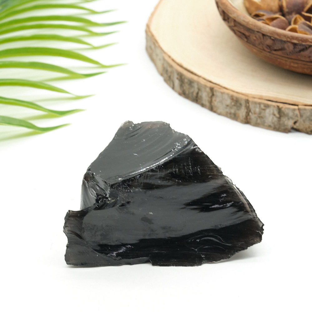 large rough black obsidian rock on white surface