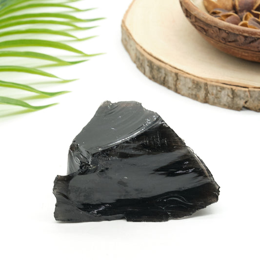 large rough black obsidian rock on white surface