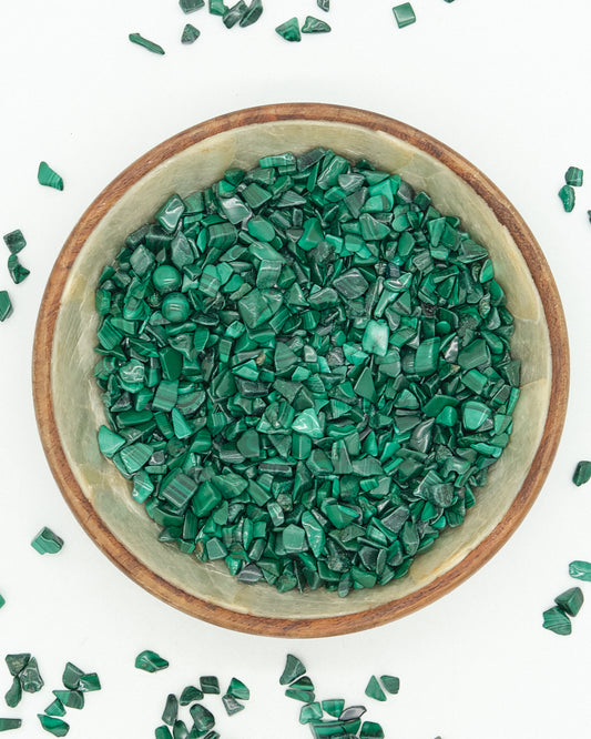 Green Malachite decorative stones in a ceramic bowl on a white background