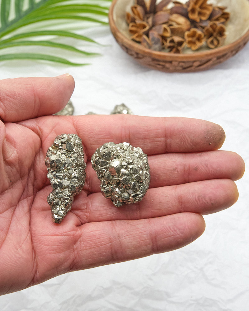 small raw gold pyrite crystal stones in a hand